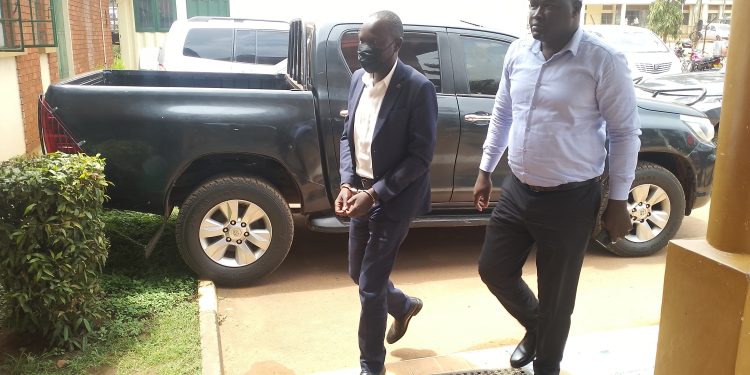 Ssekikubo escorted by detectives to court.