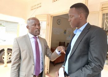 From left, Bamunanika County MP Robert Ssekitoleeko chats with Marvin Mugisha, the Katikamu South parliamentary candidate, at the Electoral Commission offices in Luwero Town.