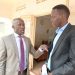 From left, Bamunanika County MP Robert Ssekitoleeko chats with Marvin Mugisha, the Katikamu South parliamentary candidate, at the Electoral Commission offices in Luwero Town.