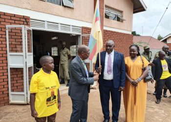 Dr. Muyingo hands over a flag to Dr. Kiyini, whom he has endorsed as his successor.
