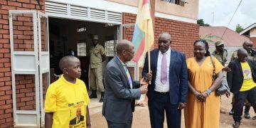 Dr. Muyingo hands over a flag to Dr. Kiyini, whom he has endorsed as his successor.