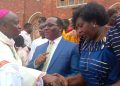 Bishop Jjumba greeting Mpuuga and Juliet Kakande after the Easter Mass