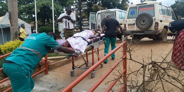 Francis Mpalanyi, Mukono municipal enforcement officer, is rushed to Mulago National Referral Hospital after sustaining severe head injuries during a kiosk demolition operation in Gunga Village