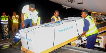 State Minister for Youth and Children Affairs Balaam Barugahara and family members receive the body of Timothy Muganzi Magambo, son of CID Director Tom Magambo, upon arrival at Entebbe International Airport on Tuesday morning.