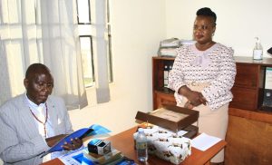 Kaliisizo Town Council Chairperson (Mayor) Richard Sande Ntambaazi handing over the official handover report to the Town Clerk, Resty Nabatanzi, marking the end of his 20-year tenure.