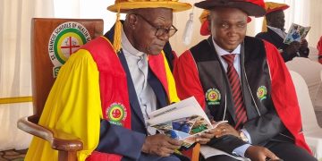Rev. Fr. Prof. John Chrysotom Maviiri shares a moment with Peter Kiwanuka Bbosa during the 13th graduation ceremony