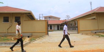 Students of St Kizito Technical Institute Kitovu walking past the new workshop built by government