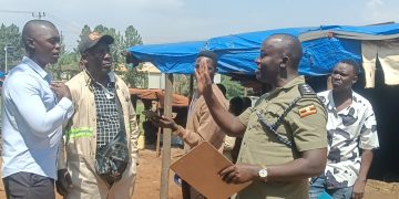 Officer in Charge of Namanve Police Station, ASP Geoffrey Tasobya, engaging and urging residents of Kolo-Buwanyi Village in Goma Sub-county, Mukono District to remain calm and allow dialogue following a standoff over Standard Gauge Railway survey equipment.