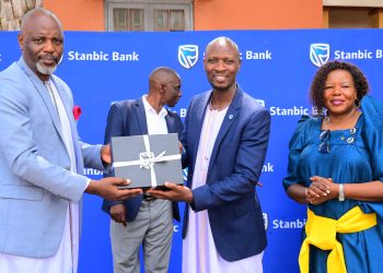 Stephen Segujja (R) Head, Economic Enterprise Restart Fund (EERF) and Cathering Poran, the CE Stanbic Business Incubator handing over a gift to the Rt. Hon. Joseph Muvawala the Prime Minister of Busoga Kin