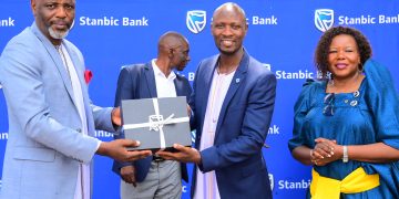 Stephen Segujja (R) Head, Economic Enterprise Restart Fund (EERF) and Cathering Poran, the CE Stanbic Business Incubator handing over a gift to the Rt. Hon. Joseph Muvawala the Prime Minister of Busoga Kin